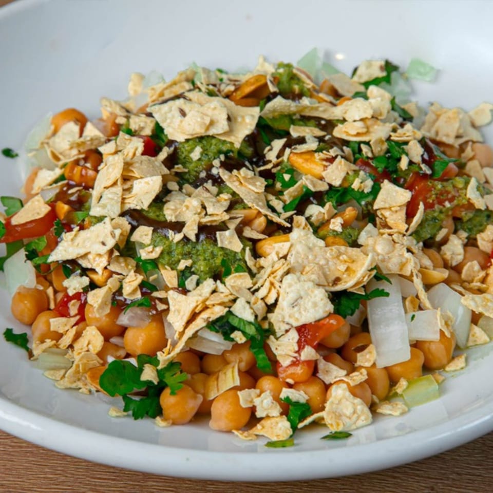A close-up of Desi Aroma's Indian chaat, featuring chickpeas, vegetables, and crispy flatbread pieces.